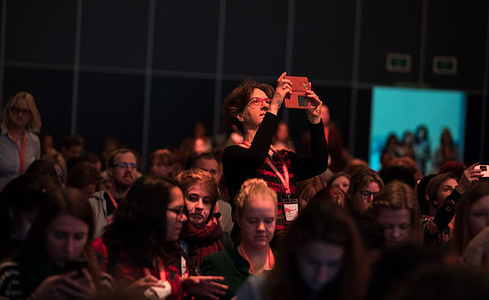 Woman in audience of DIT 2017 taking a photo with her smartphone.